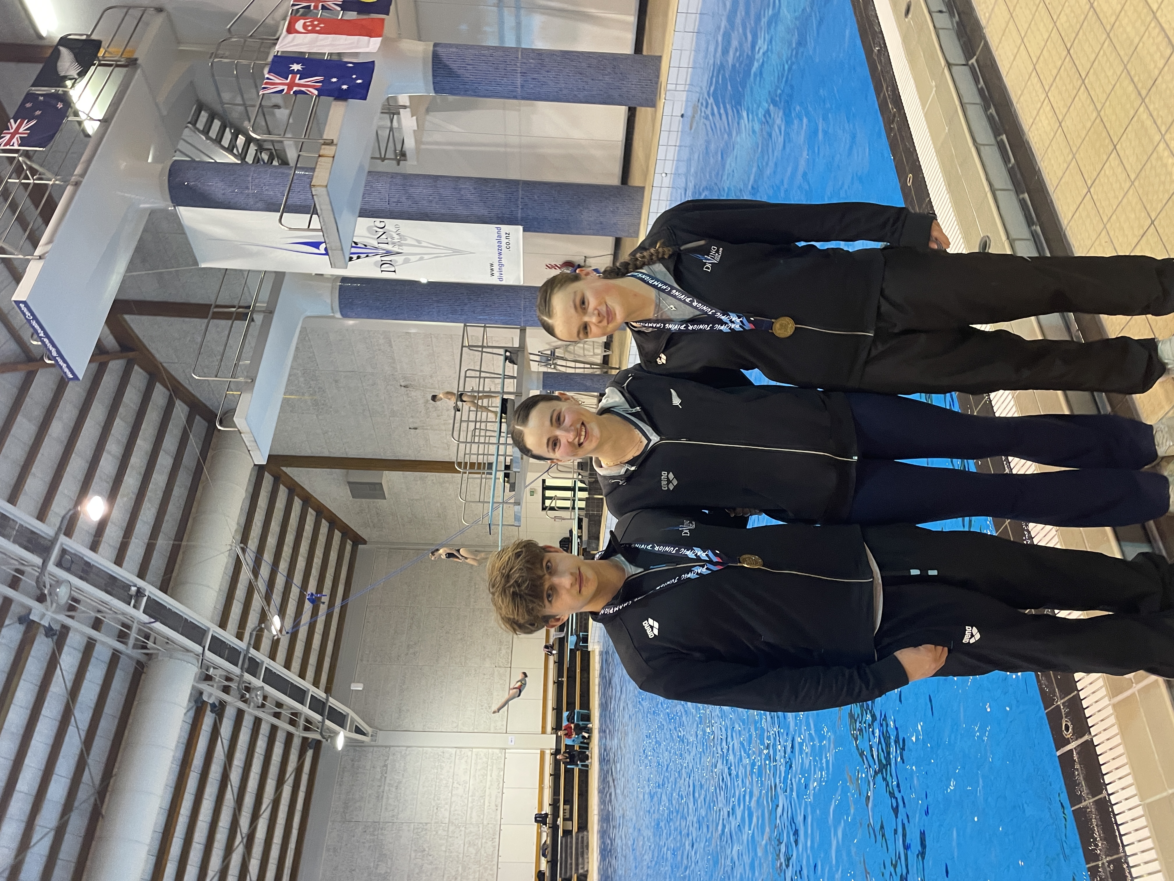Diving team and medallists beside the pool